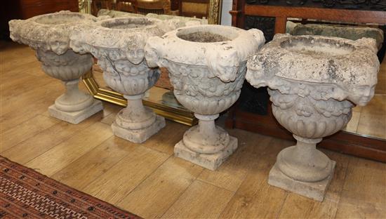 A set of four reconstituted stone urns, height 36cm, diameter 42cm